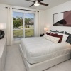 a bedroom with a nightstand, dresser and a window